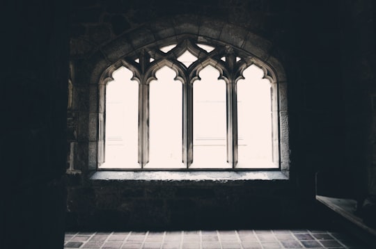 A darkened picture capturing a window inside of a church. in Brookline United States