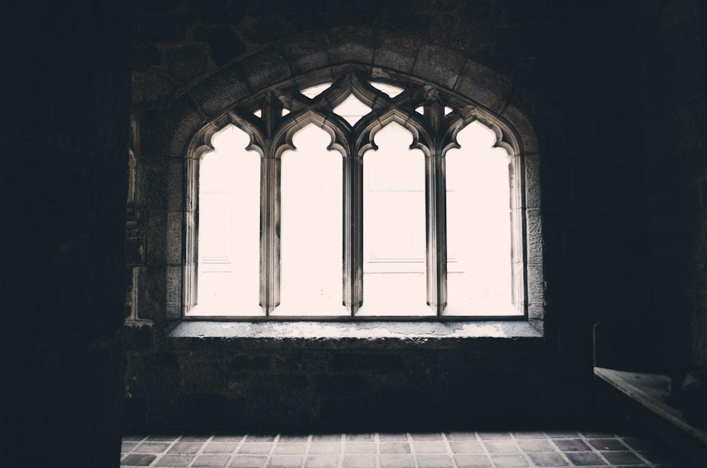 Ein abgedunkeltes Bild, das ein Fenster in einer Kirche einfängt.