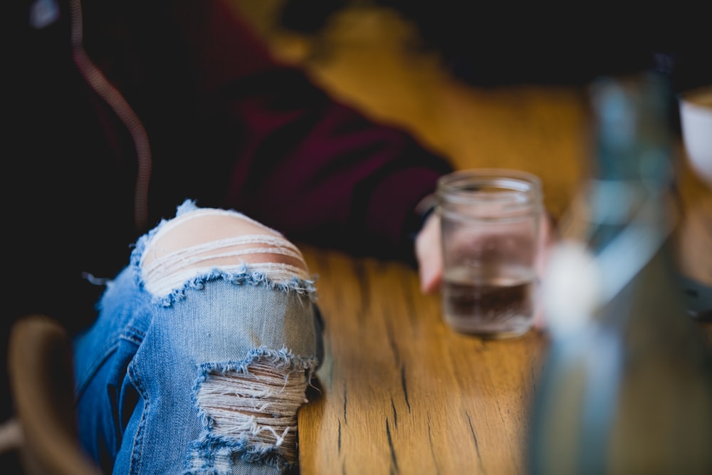 shallow focus photography of person holding drinking glass