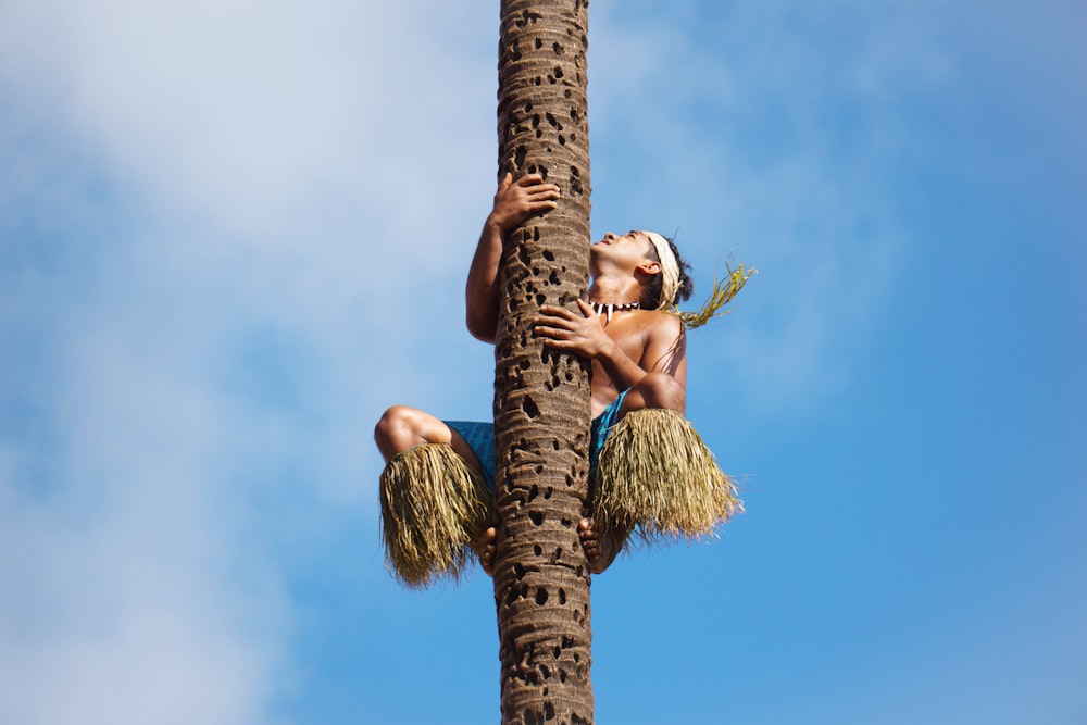 女性がヤシの木に登っている