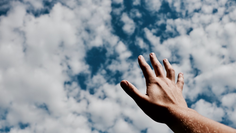 person hand reaching for the sky