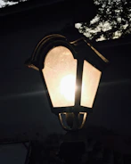 Close-up of a sleek, modern outdoor lantern glowing at dusk.