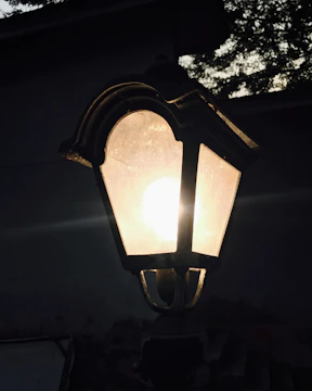 Close-up of a sleek, modern outdoor lantern glowing at dusk.