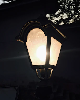 A vintage lantern glowing softly against a dark, starry night backdrop.