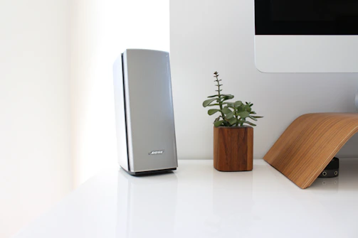 A minimalist desk setup featuring sleek gadgets and a small potted plant.