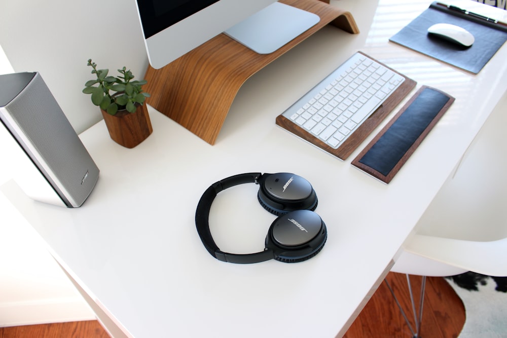 Ein Schreibtisch mit Kopfhörern, Tastatur und Handgelenkwrest, Monitor, Maus, Lautsprecher und eine Anlage.