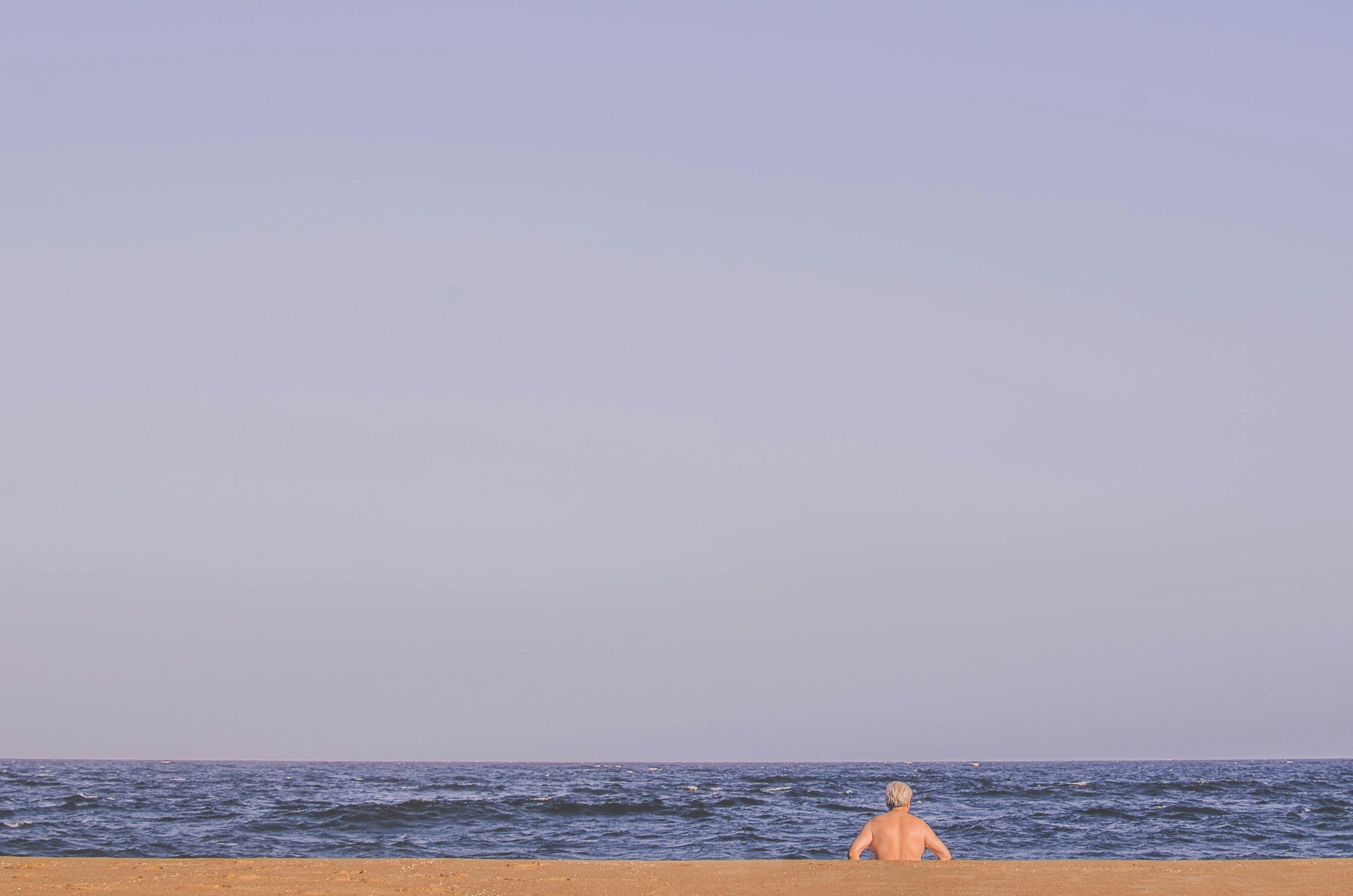 man sitting on seashore