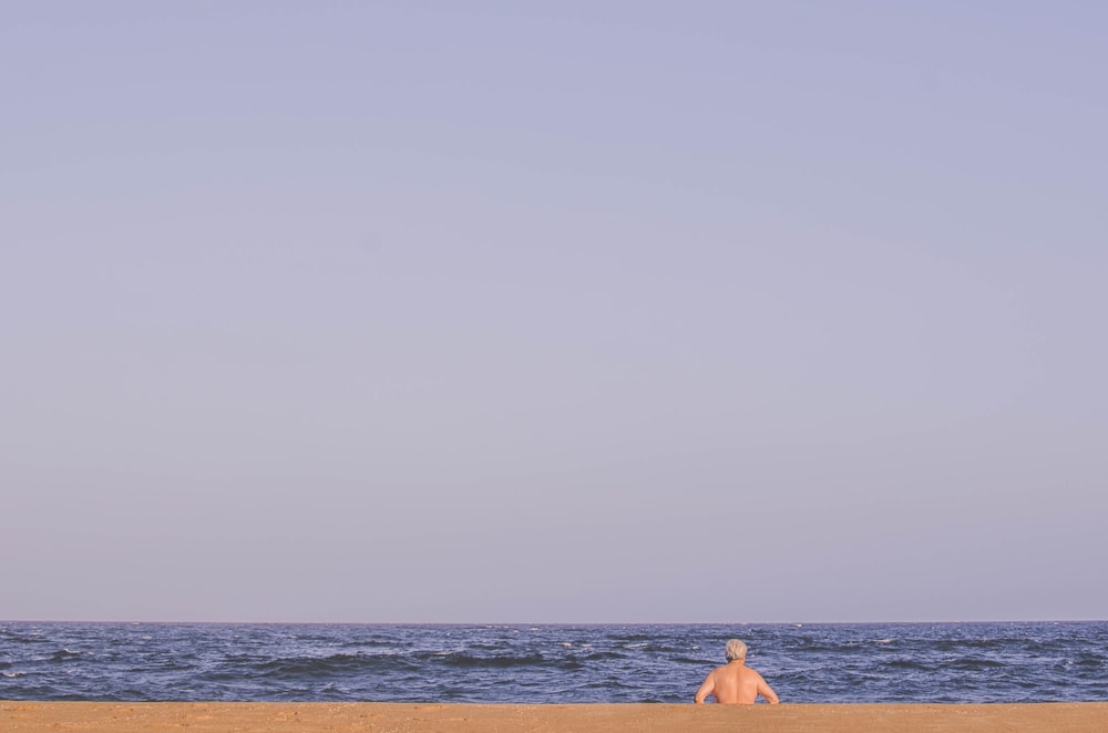 man sitting on seashore