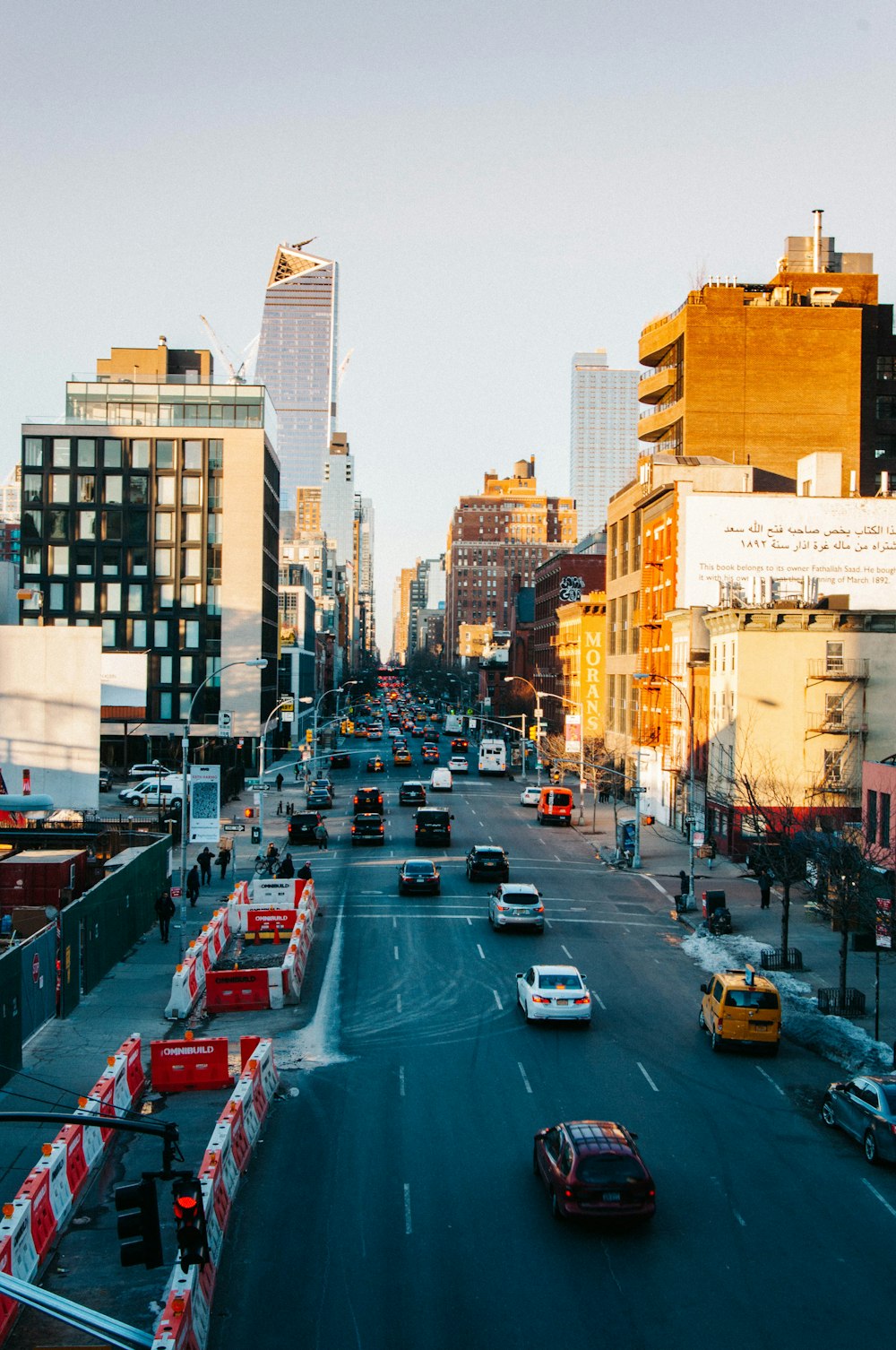 a city street filled with traffic next to tall buildings