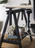 A sturdy folding table with adjustable height, shown in a home office setting.