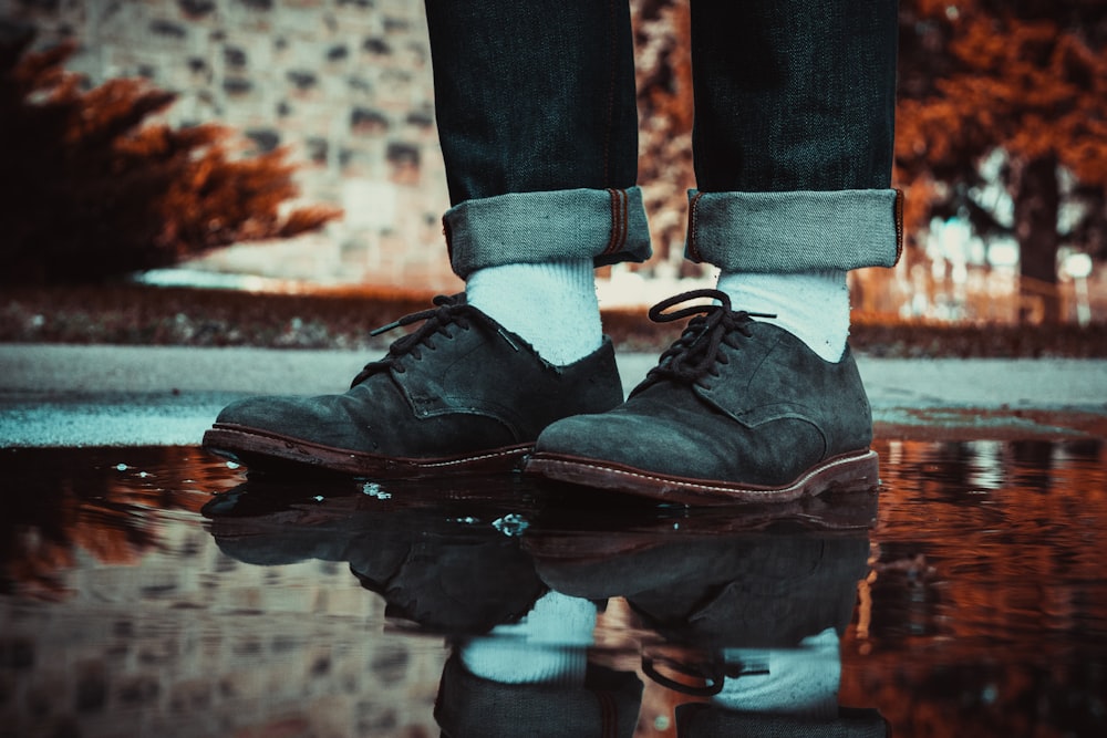 Persona con zapatos de cuero marrón pisando un charco de agua