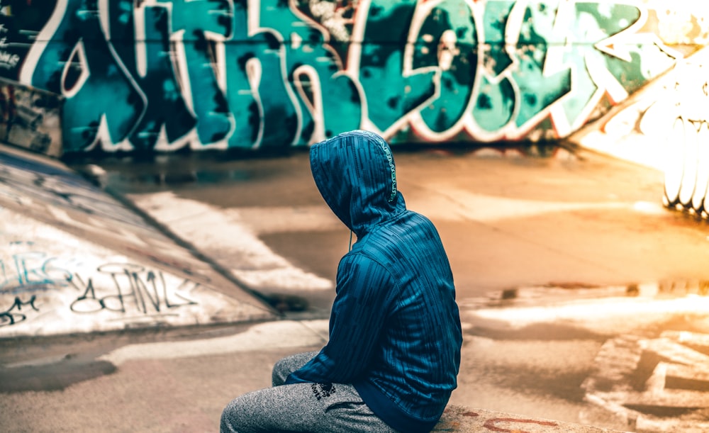 person sitting near graffiti artwork