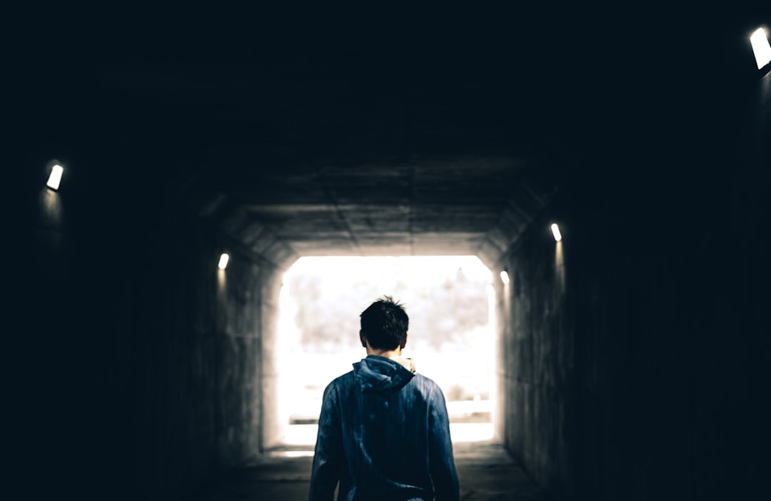 man standing in subway, … the light at the end of the tunnel.
