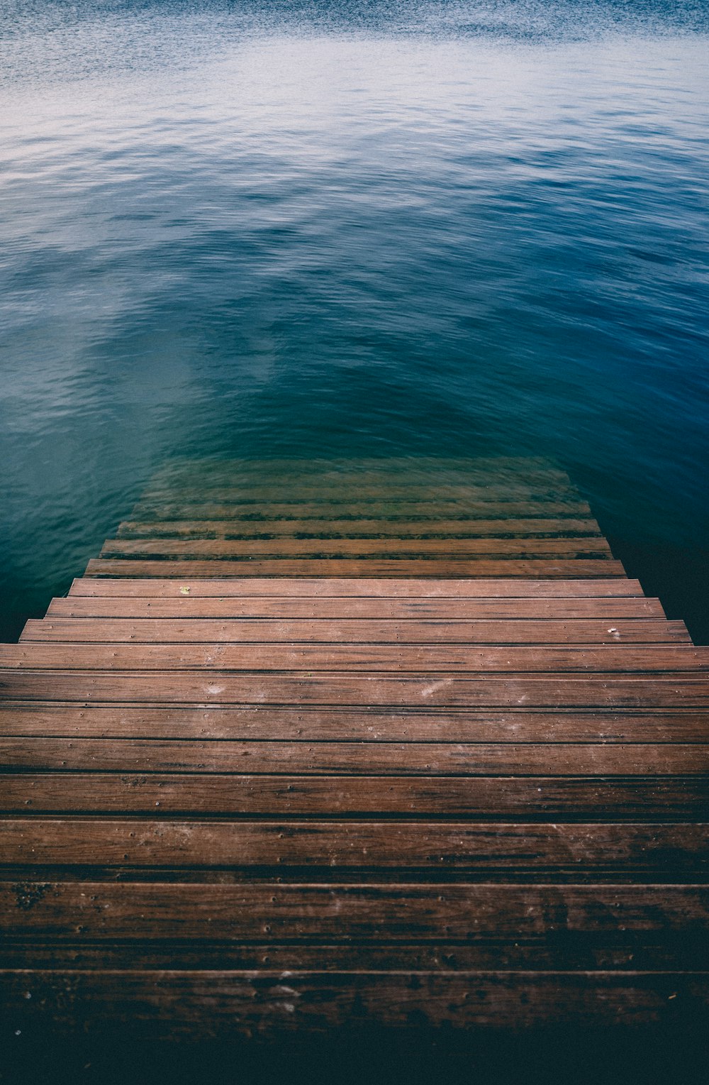 Scala di legno marrone su uno specchio d'acqua calmo