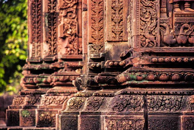Close-up detail of Banteay Srei's distinctive pink sandstone carving (via Unsplash)