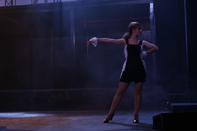 Woman gracefully dancing in stylish heels on a smooth stage floor.