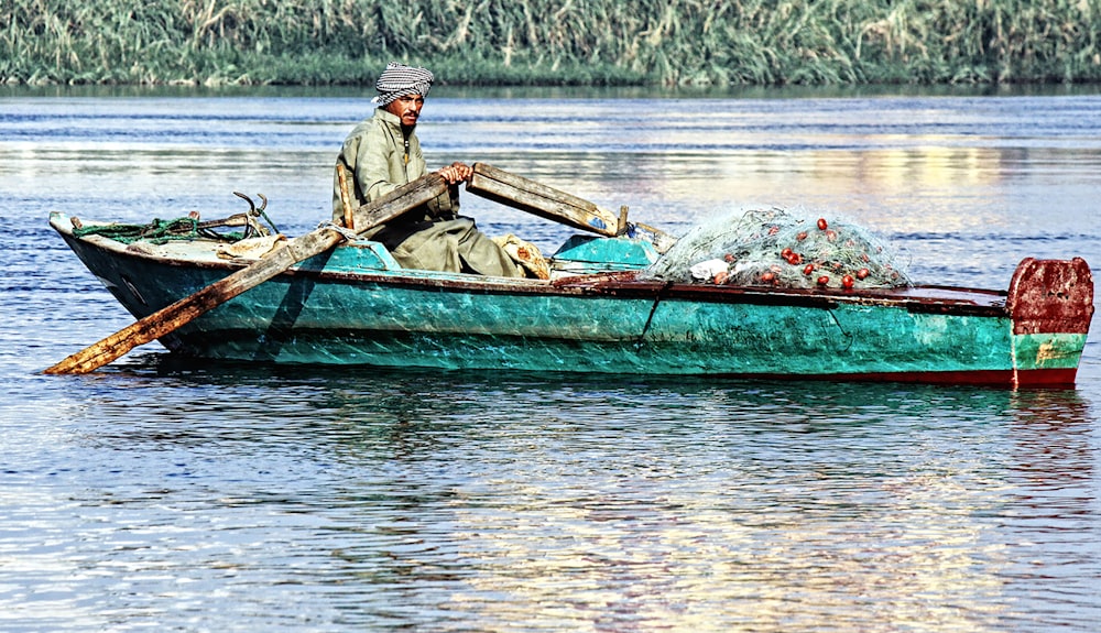 bote de remos de hombre en un lago