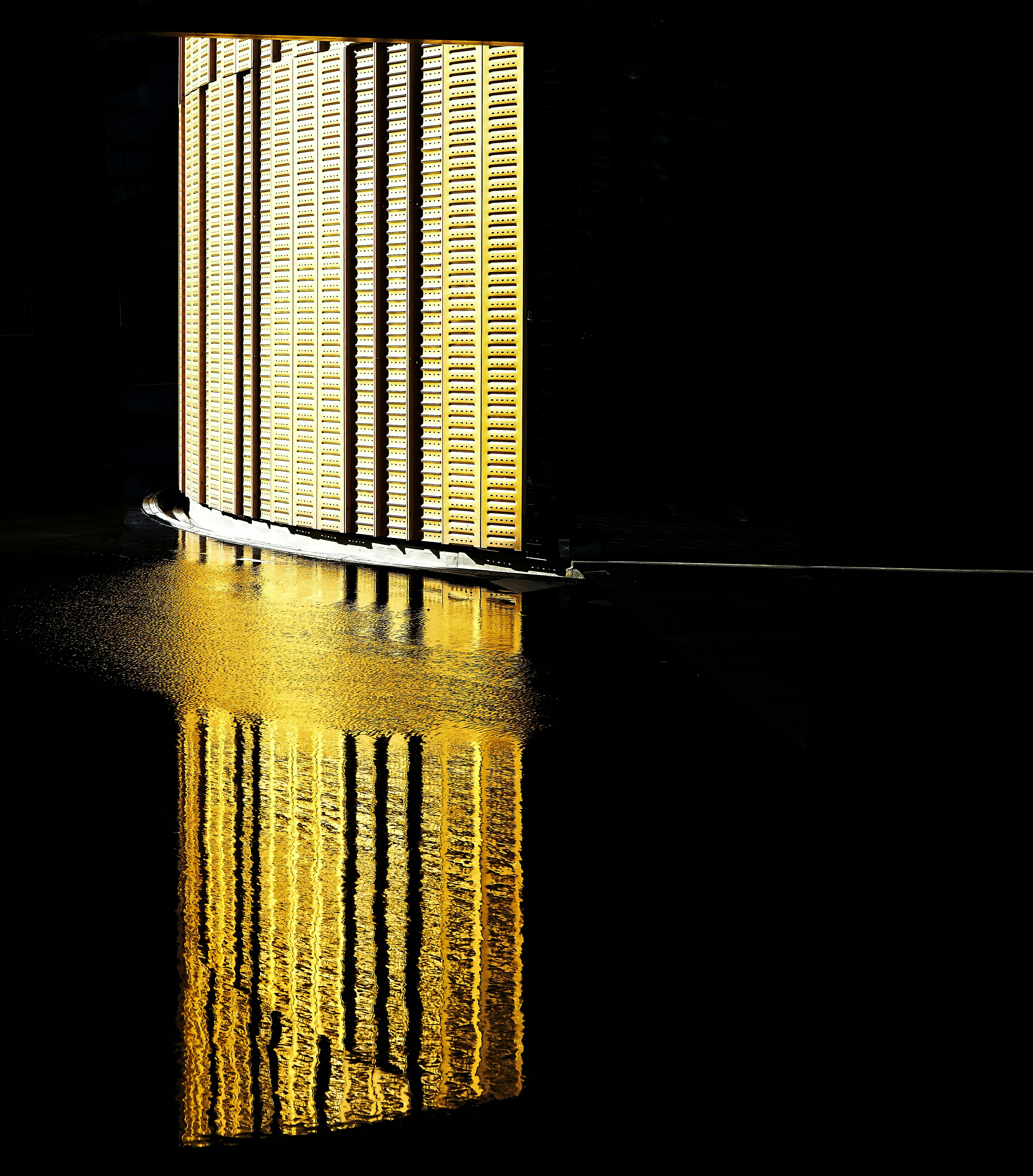 The reflection of a brightly lit wall on the water surface at Fiera Milano Rho P5.