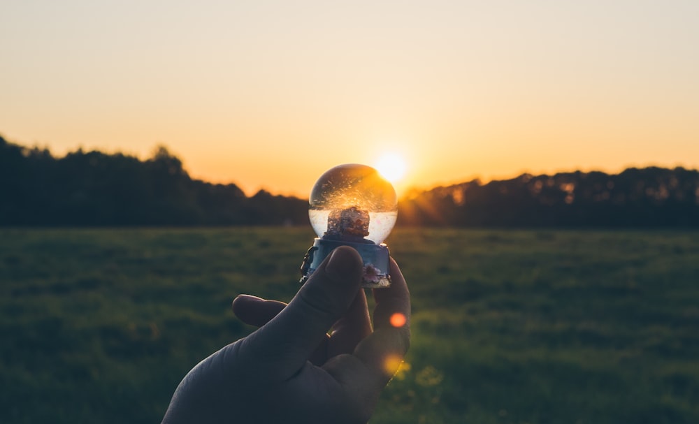 person holding water globe