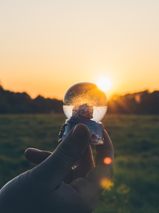 person holding water globe