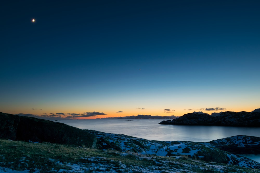 landscape photo of body of water in between land formations