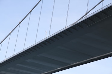 Aerial view of a bridge with a drone performing detailed inspection of its cables and joints