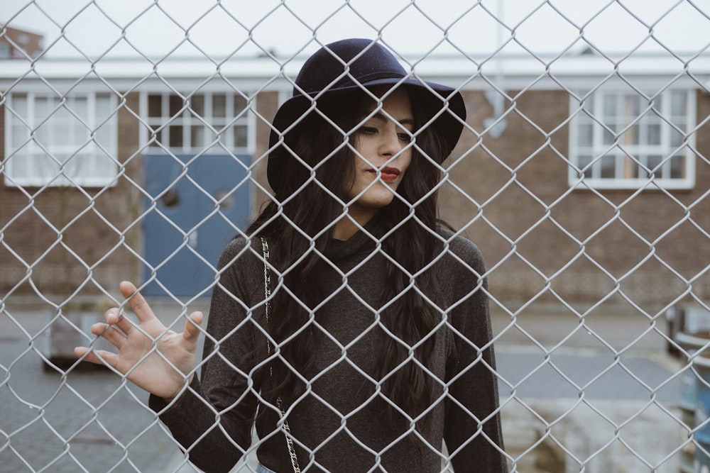 woman touching cyclone fence