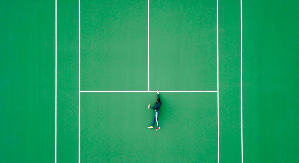 テニスコートに横たわる人物の航空写真