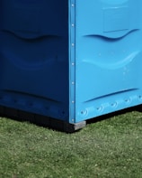blue metal storage box on green grass