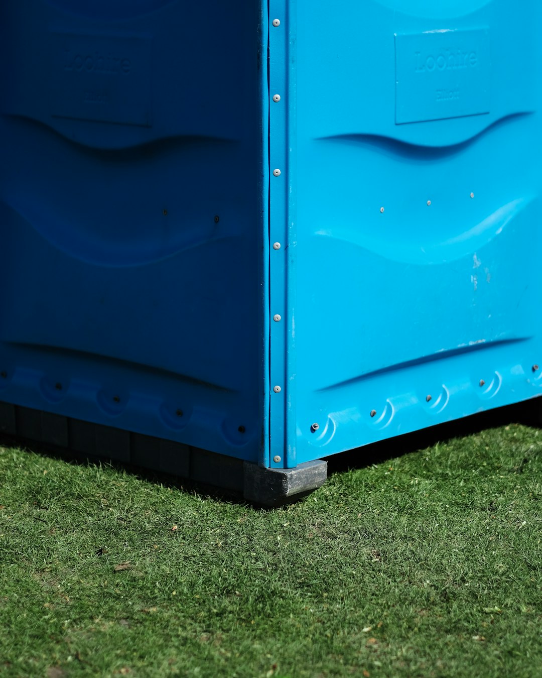 blue metal storage box on green grass