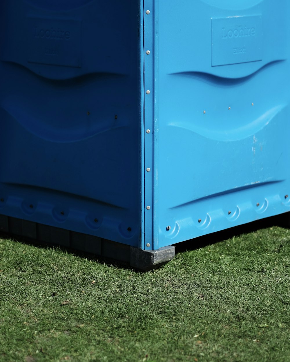 blue metal storage box on green grass