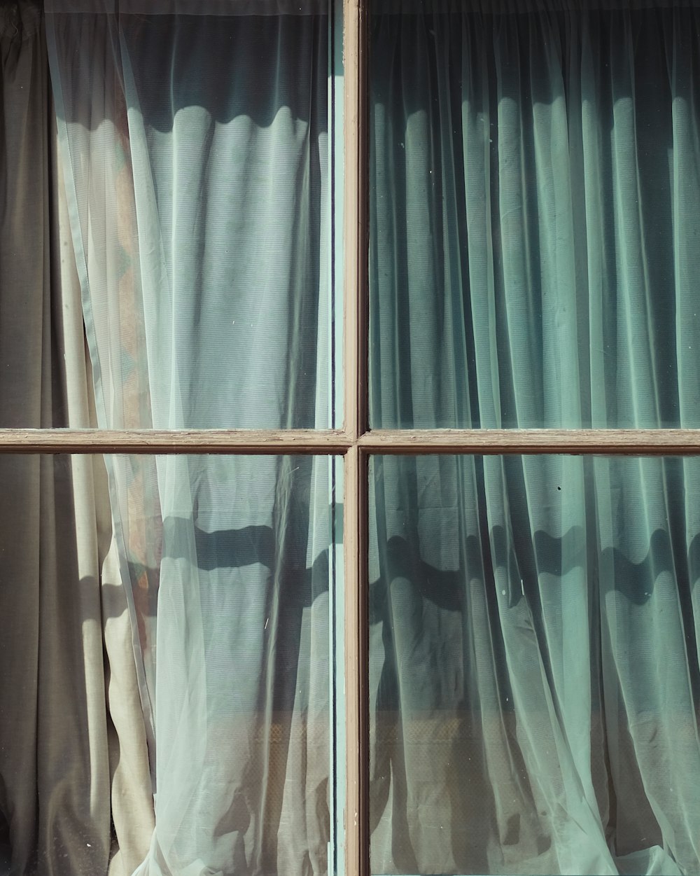glass window with teal and white curtain