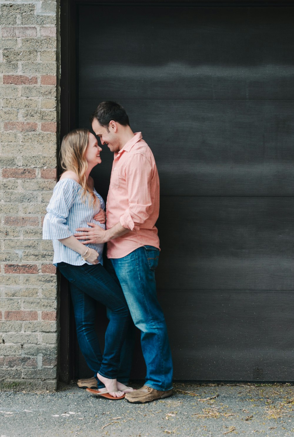 woman leaning on wall beside man