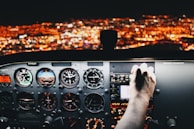 Close-up of a pilot’s hands adjusting cockpit controls during a night flight.