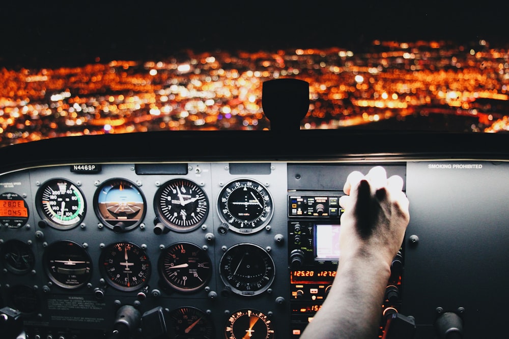 Aircraft pilot hovering a hand over the airplane control panel