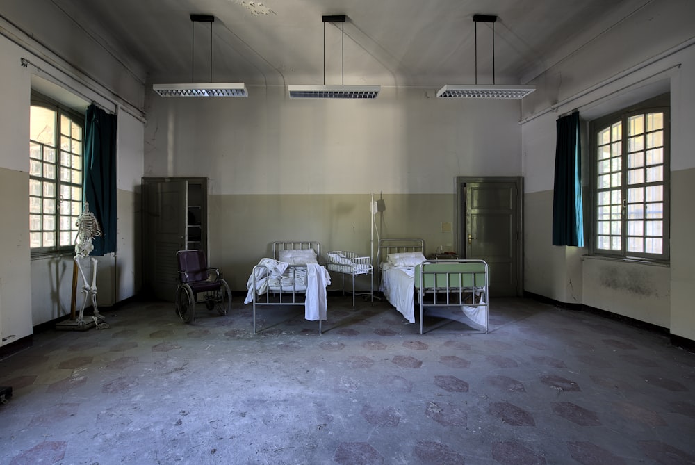 Dos camas de hospital en habitación espaciosa bajo lámparas colgantes