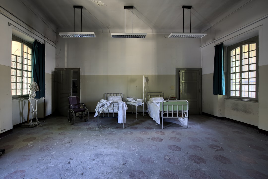 two hospital beds in spacious room under pendant lamps, the lunatics have taken over the asylum
