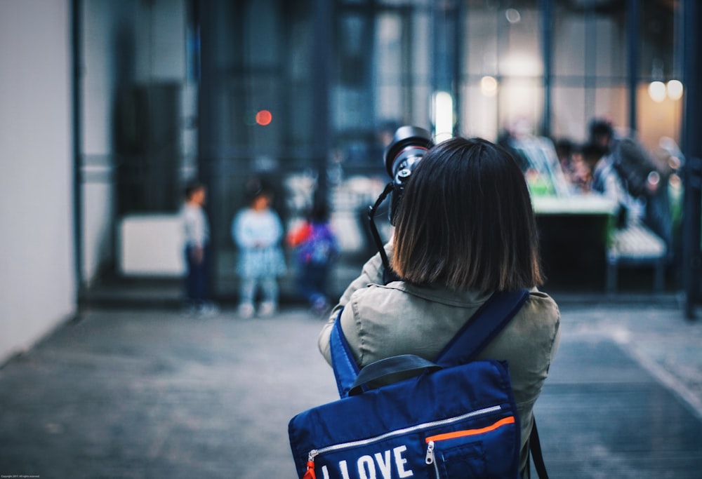 person taking picture of the building in selective focus photography