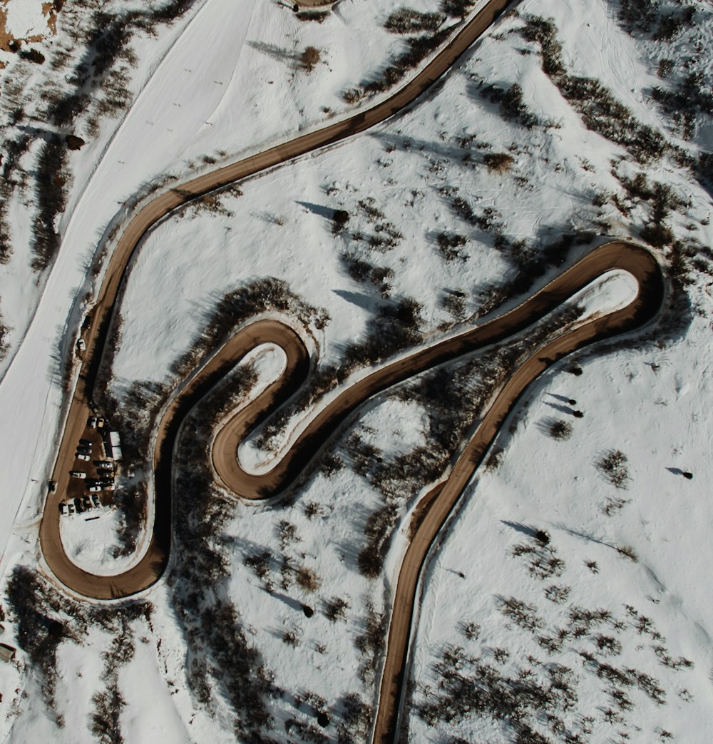 an aerial view of a winding road in the snow