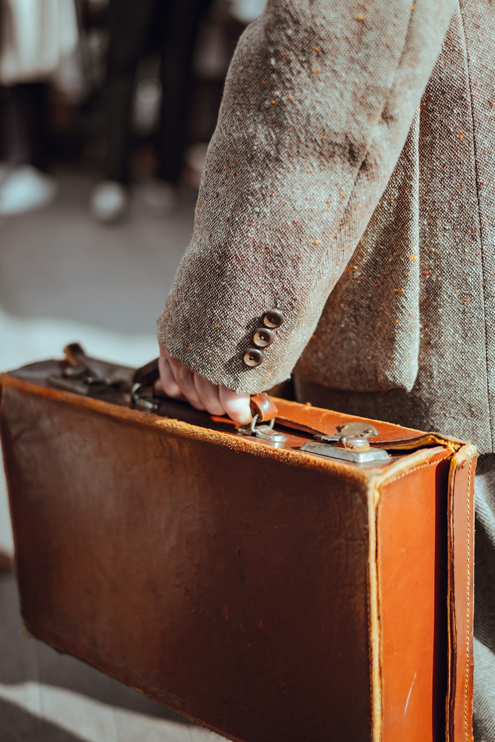 person wearing coat carrying suitcase