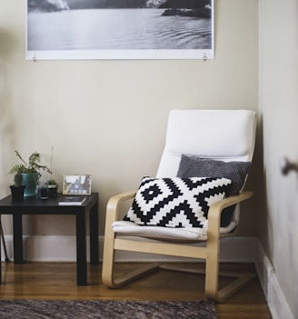 throw pillow on chair beside end table inside room