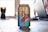 A soda can featuring a cartoon character on a skateboard, emblazoned with the words 'Exotic Soda'. The can is placed on a wooden surface with a blurred background, possibly a room with a laptop.