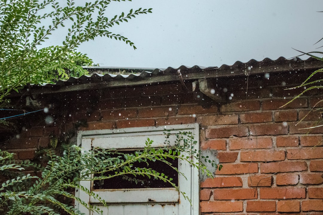 rain pouring on brick wall house