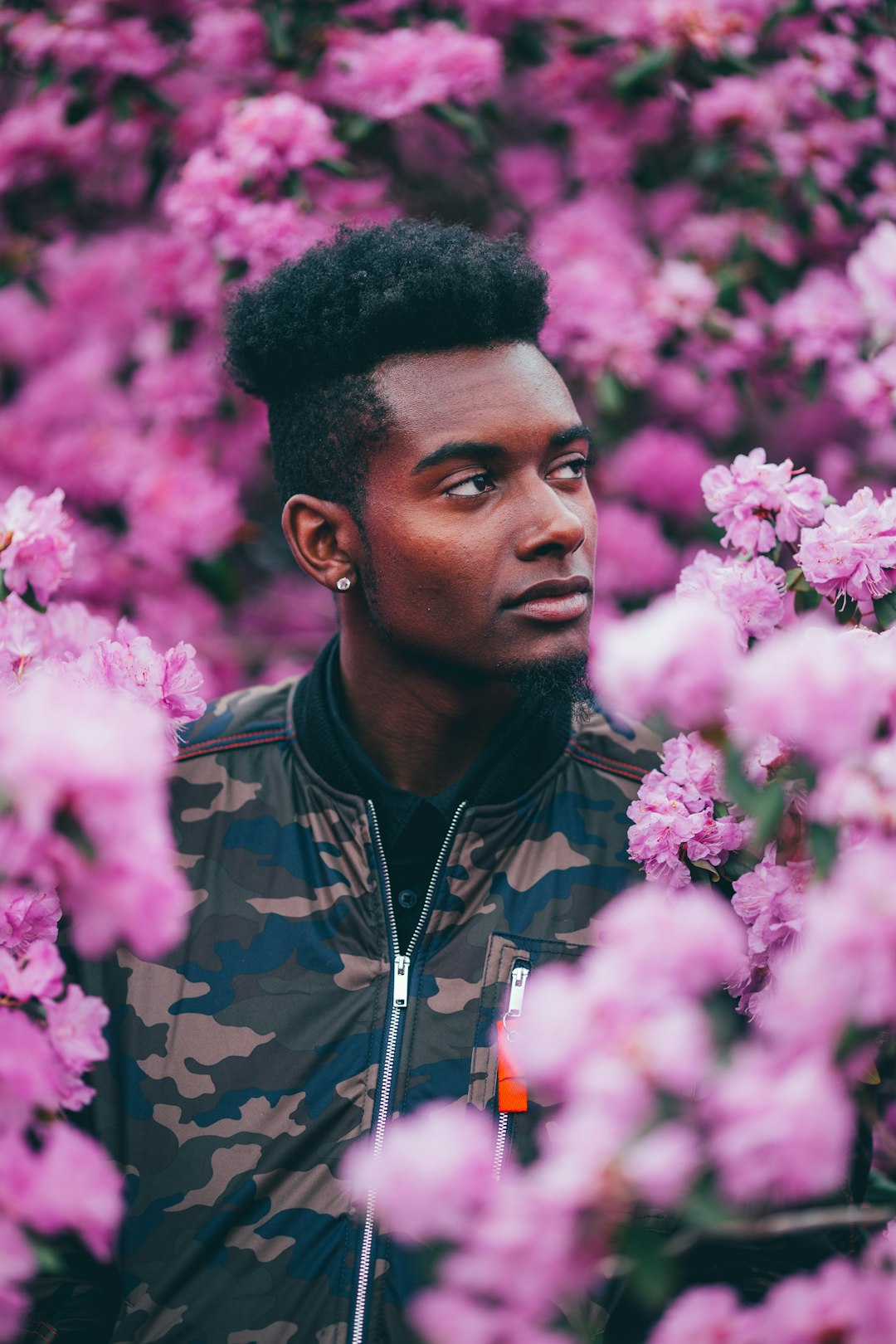 man in camouflage jacket on garden looking up