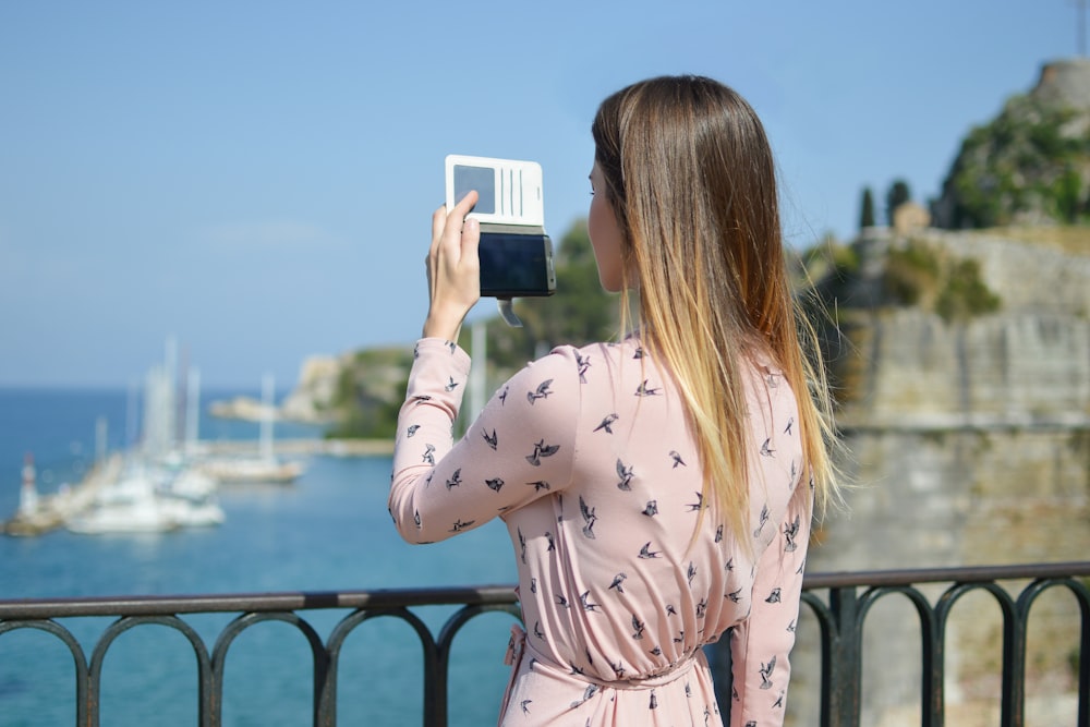 woman taking pictures near handrail