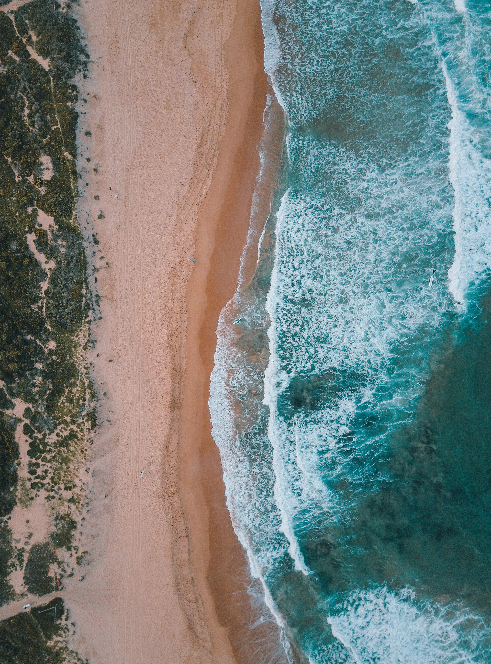 Aerial view of turquoise Caribbean water meeting a white sand shoreline