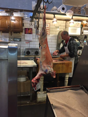 Cozy interior of a butcher shop with warm red and yellow tones and fresh meat displays.