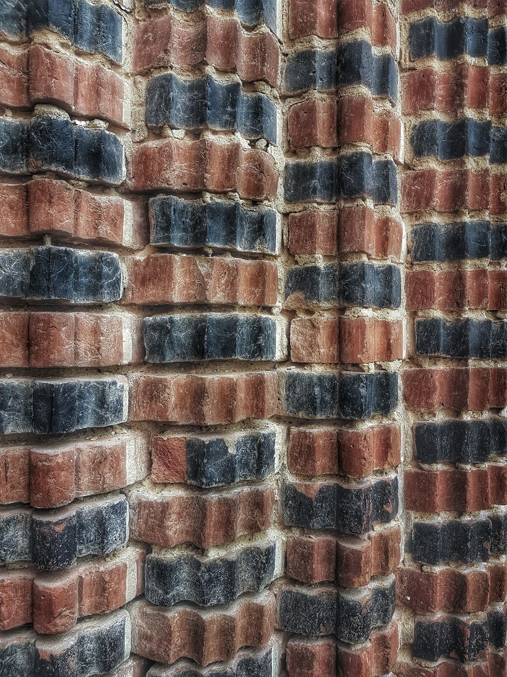 A brick wall texture pattern with black and red bricks.