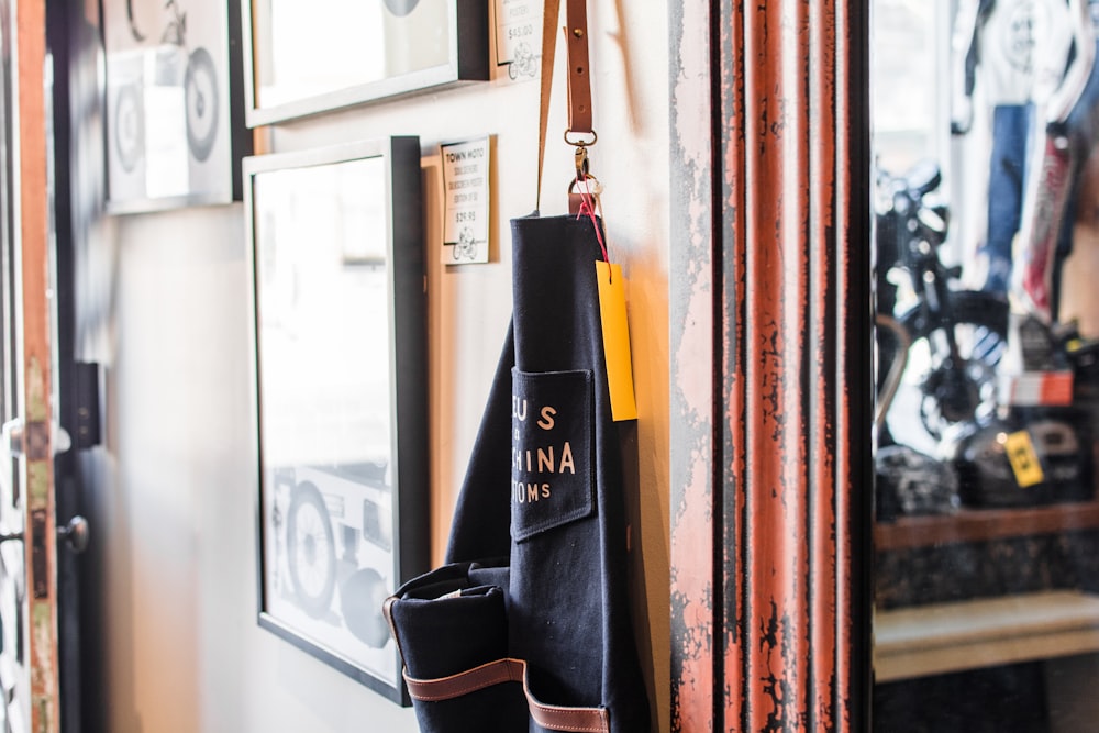 black and brown bag hanged beside wall