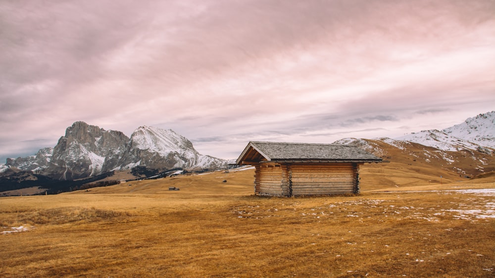 braunes Holzhaus brauner Berg umgeben von Schnee